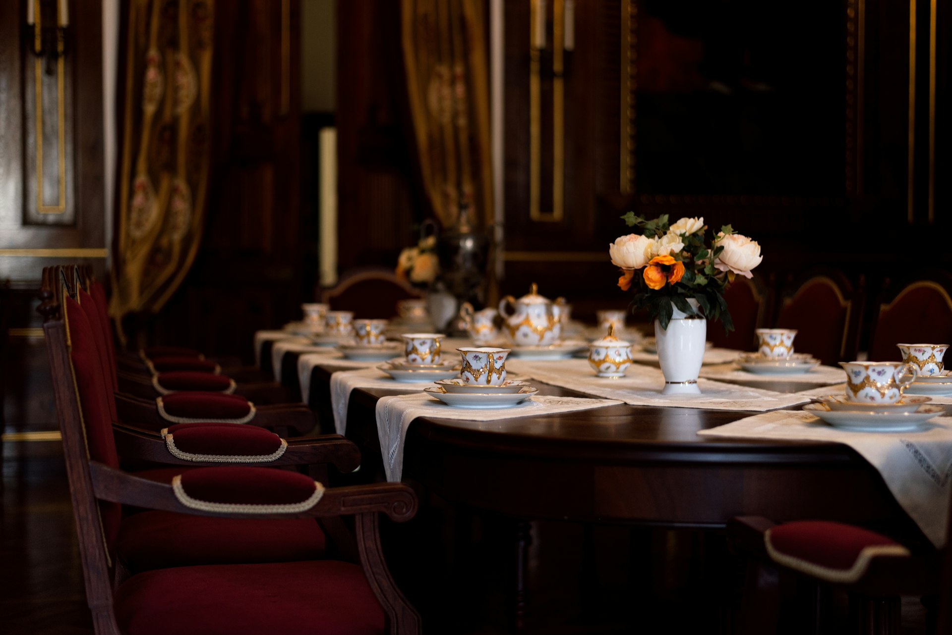 a dining table with a vase of flowers on it